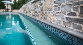 Geometric Pool with Raised Stone Wall and Pool Bench